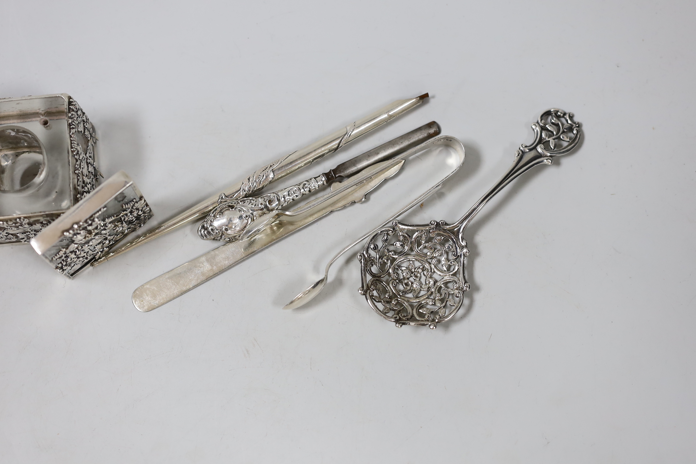 A late Victorian silver spoon, with pierced bowl and handle, Edward Hutton, London, 1893, 12.8cm, a Chinese white metal dip pen (stamped silver), a white metal mounted glass inkwell (stamped Risansha) and three other ite